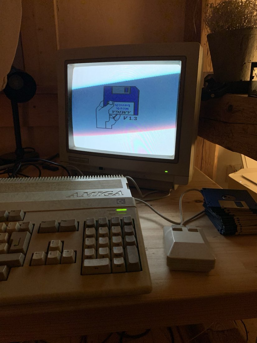 Ein Amiga 500 mit Workbench 1.3, angeschlossen an einen Röhrenmonitor, daneben ein Stapel Disketten.