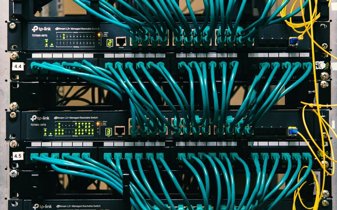 Ein Patchfeld mit vielen Netzwerkkabeln und handbeschrifteten Etiketten.